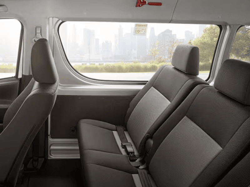 Spacious and comfortable interior seating of a Toyota commuter van for airport transfers.