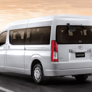 Phuket Airport Van Transfer: White Toyota commuter van driving on a smooth road during sunrise, ideal for airport transfers.