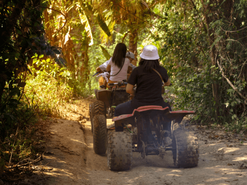 Back view of an ATV group ride through dense forest trails in Phuket, offering a thrilling outdoor experience.