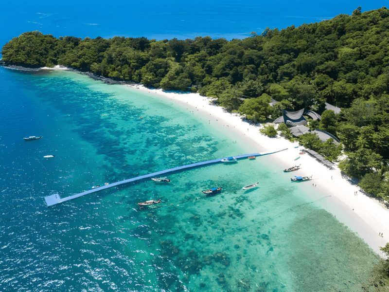 A breathtaking aerial view of Coral Island's pristine beach with turquoise waters, white sands, and lush greenery. Perfect for relaxing and adventure-filled island tours.