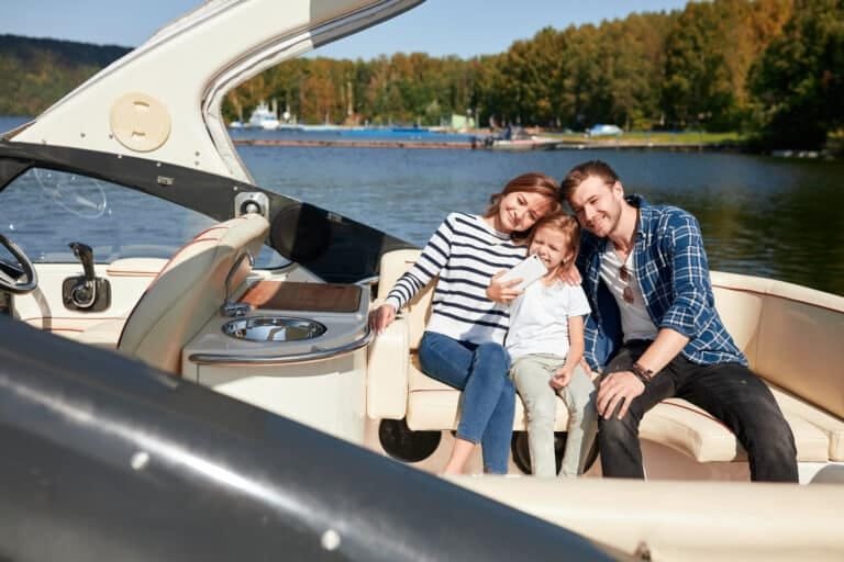 family tours in Phuket: Smiling family of three enjoying a sunny day on a luxury boat, capturing precious memories.