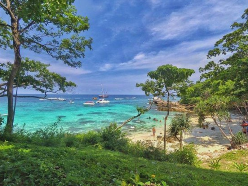 A stunning view of Khai Island with turquoise waters, white sandy beaches, and lush greenery under a clear blue sky.