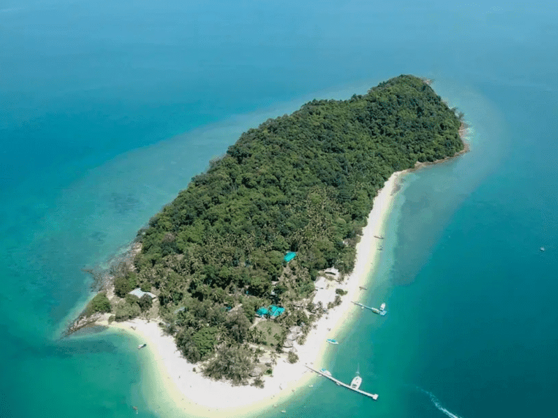 Full aerial view of Naka Noi Island surrounded by turquoise waters and lush greenery, ideal for private charters.