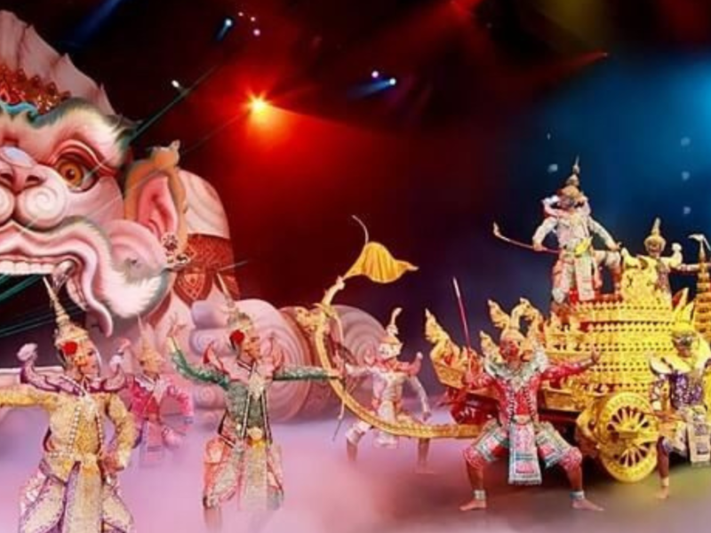 Performers in traditional Thai costumes during an epic theatrical show at Phuket Fantasea, featuring golden chariots and a dramatic mythical backdrop.