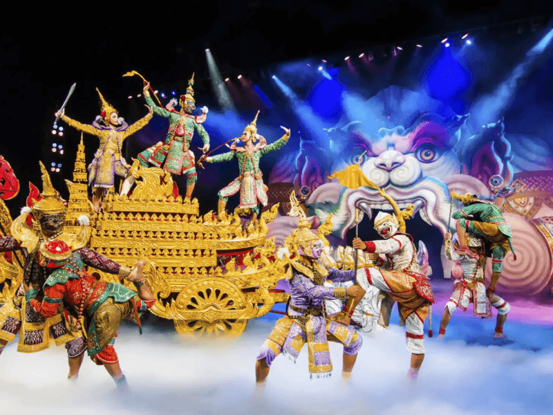 Performers in elaborate Thai costumes enact a Ramayana-themed show at Phuket Fantasea, featuring golden chariots and a dramatic stage backdrop.