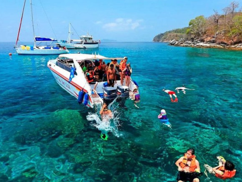 Racha Island Private Charter: A private speedboat with tourists enjoying snorkelling in the turquoise waters of Racha Island, surrounded by vibrant marine life.