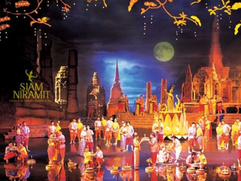 Performers at Siam Niramit Phuket enact a beautiful Loy Krathong scene with traditional costumes, floating lanterns, and historical temple backdrops.