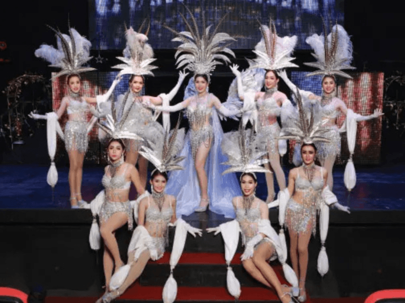 Simon Cabaret Show: Performers at the Simon Cabaret Show in Phuket, dressed in glamorous silver costumes with feathered headdresses, posing on stage.