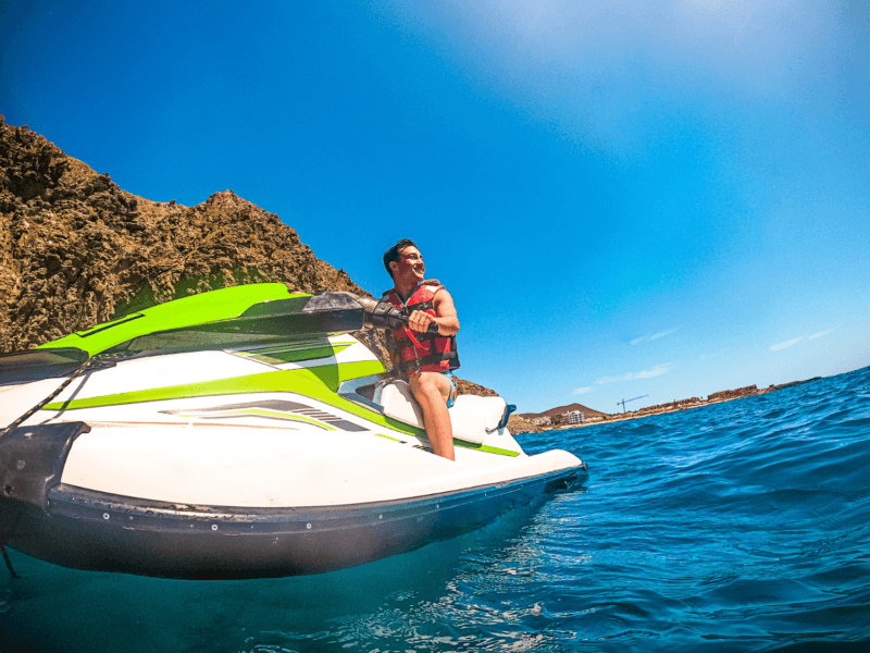 Solo Traveler Enjoying a Jet Ski Ride in Phuket with Stunning Cliffside Views