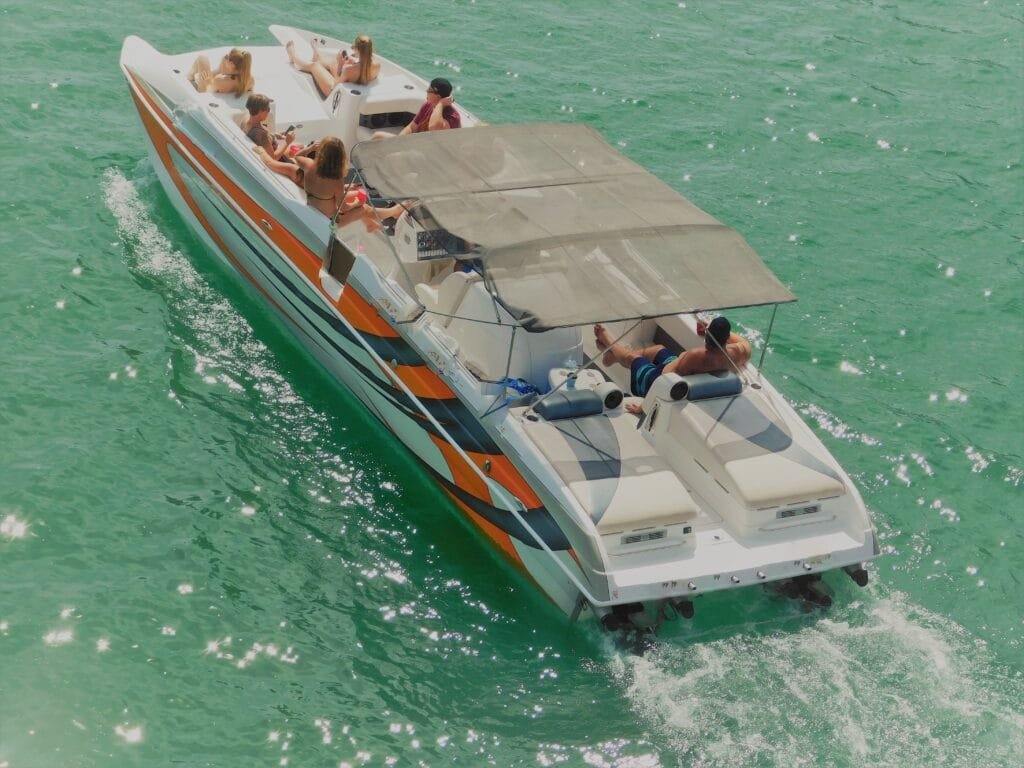 Private Speedboat in Phuket: A family enjoying a summer vacation on a private speedboat in Phuket, showcasing the clear green waters and luxurious boat amenities.