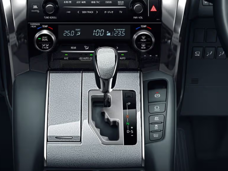 Close-up of the Toyota Alphard's luxury gear shift console with digital controls and sleek finish.