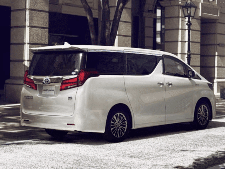 phuket airport transfers: Rear side view of the Toyota Alphard luxury van parked in an urban setting.