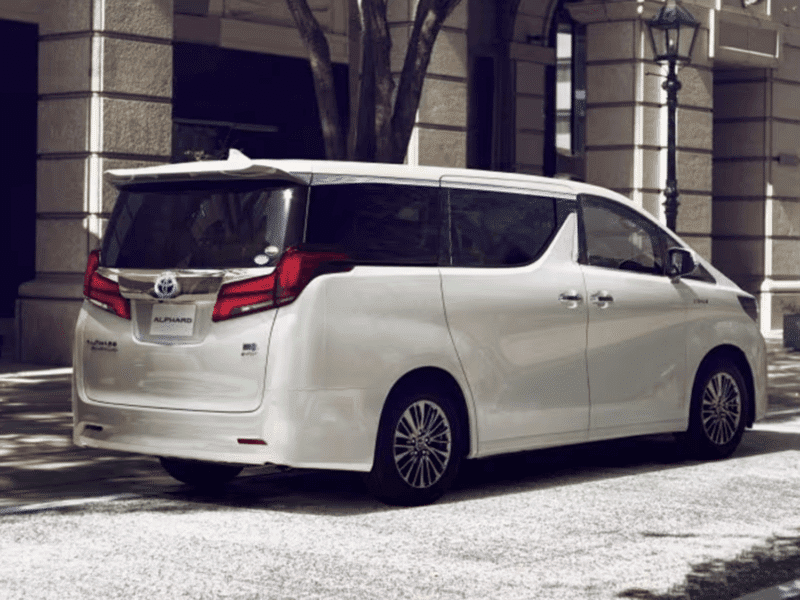 Rear side view of the Toyota Alphard luxury van parked in an urban setting.