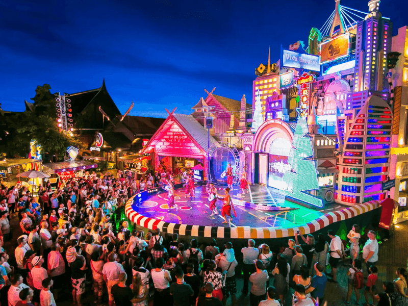 A vibrant crowd gathers at the Viva Bangkok stage show in Phuket, featuring dazzling lights, colourful performances, and an energetic atmosphere.