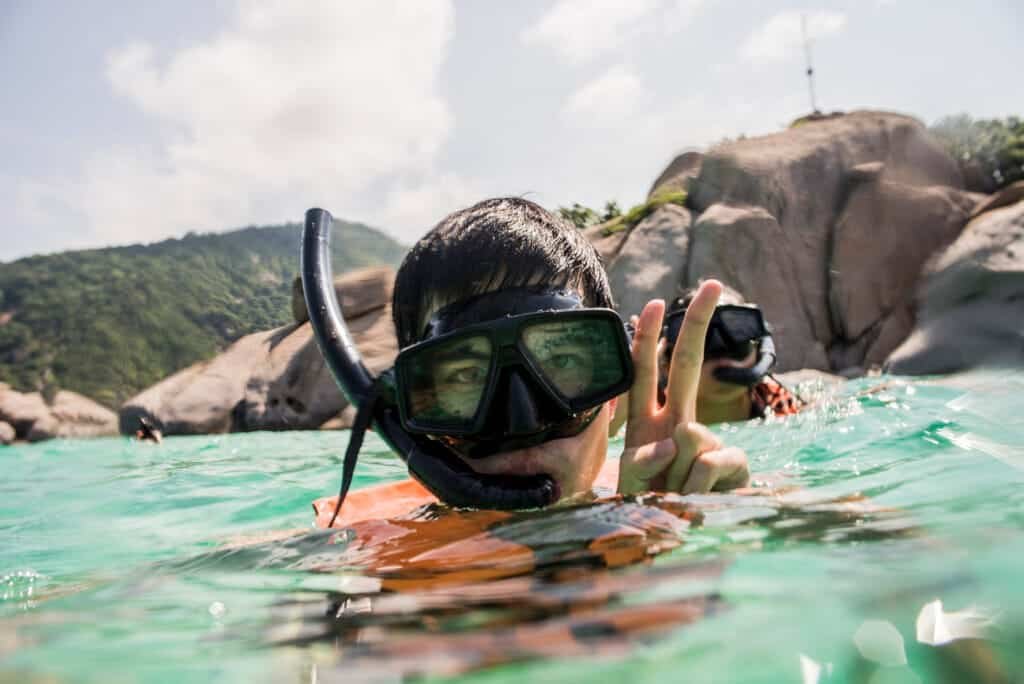 snorkelling spots in Phuket: Young man snorkelling at Nangyuan Island, crystal-clear waters.