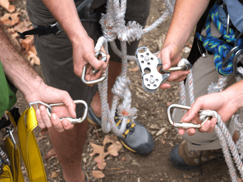 Close-up of hands holding zipline safety equipment, including carabiners and ropes, essential for a thrilling adventure in Phuket.