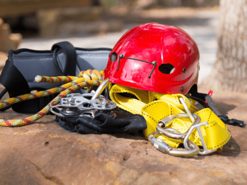 Essential zipline safety gear, including a red helmet, harness, and ropes, ready for an adventurous experience in Phuket.