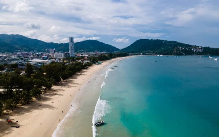 adventurer guide to Phuket: A stunning aerial view of Patong Beach, Phuket, with turquoise waters and vibrant cityscape in the background.